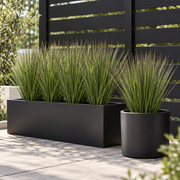Artificial grass plants arranged in a planter for outdoor styling