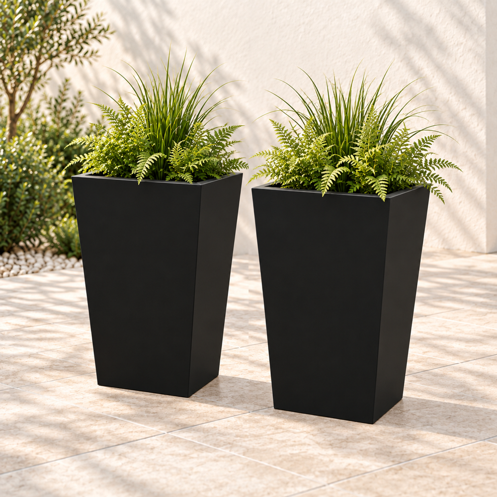 Two black tapered metal planters, each 26 inches high with greenery in an outdoor setting.