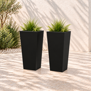 Two black tapered metal planters, each 30 inches high with greenery in an outdoor setting.