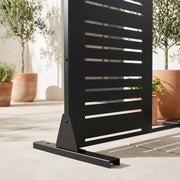 Close-up of mixed-width louvered metal privacy screen frame and base detail