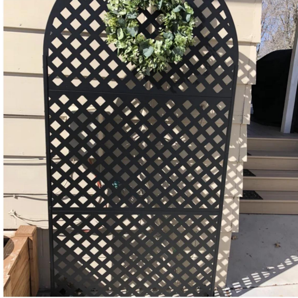 Decorative arched metal privacy screen adding style and privacy to an outdoor space