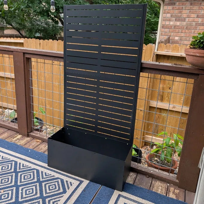 Outdoor privacy screen used as a trellis with plants in a backyard setting